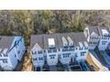 Drone view of three-story townhome with gray siding, and gray roof shingles at 113 Claret Cup Way, Charleston, SC 29414