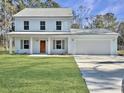 Two-story light blue house with a double garage and a manicured lawn at 1421 Brownswood Rd, Johns Island, SC 29455