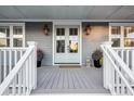 Inviting front porch with light gray flooring, white railings, and stylish lanterns at 1646 Red Tide Rd, Mount Pleasant, SC 29466