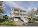 Two-story house with gray siding, double front porch, and stairs leading to the entrance at 209 Charleston Blvd, Isle of Palms, SC 29451