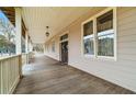 Long front porch with wooden floors and white railings at 3687 Hilton Dr, Johns Island, SC 29455