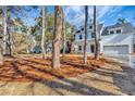 Two-story white house nestled among trees, showcasing curb appeal at 5294 Seewee Rd, Awendaw, SC 29429