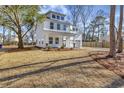 Two-story white house with gray roof, landscaping, and a large backyard at 5294 Seewee Rd, Awendaw, SC 29429