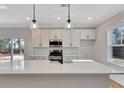 Modern kitchen with white cabinets, quartz countertops, and stainless steel appliances at 5294 Seewee Rd, Awendaw, SC 29429
