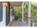 Charming front porch with rocking chairs, offering a relaxing view of the lush greenery at 6800 Back Bay Dr, Isle of Palms, SC 29451