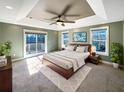 Large main bedroom with a tray ceiling, sliding glass doors to deck, and plush carpet at 7228 Mossy Creek Ln, Hanahan, SC 29410