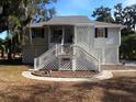 Elevated home with white exterior, lattice details, and stairs at 745 Fairway Dr, Edisto Island, SC 29438