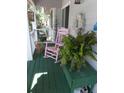Relaxing front porch with pink rocking chair and green flooring at 745 Fairway Dr, Edisto Island, SC 29438