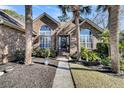 Front view of charming brick home with walkway and lush landscaping at 1449 Waterside Ct, Mount Pleasant, SC 29464