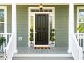 Dark wood front door with sidelights and potted plants at 1504 Galloway Ln, Charleston, SC 29412