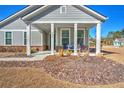 Gray house with a front porch and landscaped yard at 2020 Parish House Cir, Johns Island, SC 29455