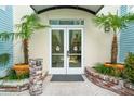 Welcoming entrance with double doors, flanked by tropical plants in pots at 5804 Palmetto Dr # A-405/407, Isle of Palms, SC 29451