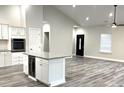 Open concept kitchen with island, granite countertops, and grey vinyl plank flooring at 101 Brien, Walterboro, SC 29488