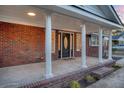 Inviting front porch with brick columns and a black door at 1111 Barrett Rd, Charleston, SC 29407