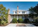 White two-story home with a metal roof, screened porch, and brick chimneys at 222 Haddrell St, Mount Pleasant, SC 29464