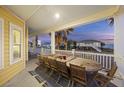 Large covered porch with outdoor dining set and ocean views at 309 Palmetto Blvd, Edisto Island, SC 29438