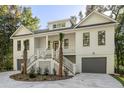 White two-story house with gray garage doors and palm trees at 5105 St George Ln, Hollywood, SC 29449