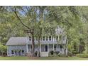 Two story house with wrap around porch, mature landscaping and trees at 820 Pineneedle Way, Charleston, SC 29492
