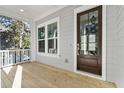 Bright front porch with a dark brown door and white railings at 1461 Lieben Rd, Mount Pleasant, SC 29466