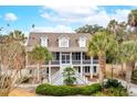Two-story house with a large front yard, palm trees, and a basketball hoop at 15 31St Ave, Isle of Palms, SC 29451