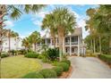 Two-story house with a large front yard, palm trees, and a basketball hoop at 15 31St Ave, Isle of Palms, SC 29451