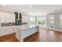 Modern kitchen with white cabinets, island, and hardwood floors at 1892 Grover Rd, Johns Island, SC 29455