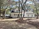 Two-story white farmhouse with a landscaped yard and mature trees at 3315 Hopkinson Plantation Rd, Johns Island, SC 29455