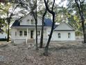 White two-story farmhouse nestled among lush trees at 3315 Hopkinson Plantation Rd, Johns Island, SC 29455