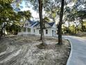 White farmhouse with driveway and large trees at 3315 Hopkinson Plantation Rd, Johns Island, SC 29455
