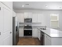 Modern kitchen with white cabinets, granite countertops, and stainless steel appliances at 415 Broad Elm Way, Summerville, SC 29486
