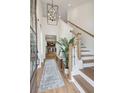 Bright and spacious entryway with hardwood floors, a statement light fixture, and a staircase at 457 Eagleview Dr, Moncks Corner, SC 29461
