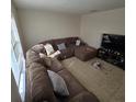 Sunlit living room with sectional sofa, tile floors, and large TV at 6884 Shahid Row, North Charleston, SC 29418