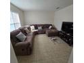 Sunlit living room with sectional sofa, tile floors, and large TV at 6884 Shahid Row, North Charleston, SC 29418