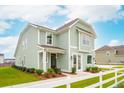 Two-story light green house with white trim and landscaping at 729 Opal Wing St, Moncks Corner, SC 29461