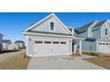 Two-story house with gray siding, white garage door, and landscaping at 767 Opal Wing St, Moncks Corner, SC 29461