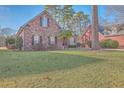 Brick home with a landscaped lawn and large tree at 8736 Herons Walk, North Charleston, SC 29420