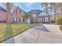 Brick home with a landscaped lawn and a long driveway at 8736 Herons Walk, North Charleston, SC 29420