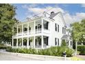 Charming two-story white house with large front porch and lush landscaping at 124 Mary St, Mount Pleasant, SC 29464