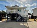 Elevated beach house with wrap around porch and stairs at 1306 Palmetto Blvd, Edisto Beach, SC 29438