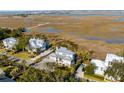 Aerial view showcasing a white house and neighboring homes near a marsh at 2618 Raven Dr, Sullivans Island, SC 29482