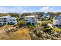 Aerial view of a neighborhood of houses, including a white two-story home at 2618 Raven Dr, Sullivans Island, SC 29482