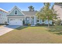 Quaint two-story house with a white door and attached garage at 311 Calm Water Way, Summerville, SC 29486