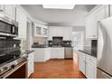Modern kitchen with white cabinets, granite counters, and stainless steel appliances at 8604 Fox Hollow Rd, North Charleston, SC 29420