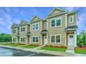 Tan three-unit townhome building with white doors and landscaping at 1001 Twin Rivers Dr # 65, Wando, SC 29492