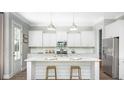 White kitchen features an island with marble countertops at 1443 Clay Field Trl, Summerville, SC 29485