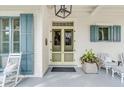 Inviting front porch with light yellow double doors and blue shutters at 1738 Ion Ave, Sullivans Island, SC 29482
