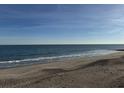 Sandy beach with ocean waves and clear sky at 305 Matilda St, Edisto Beach, SC 29438