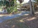 Elevated home with gravel driveway and surrounding trees at 506 Jungle Rd, Edisto Island, SC 29438