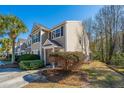 Tan two-story house with dark shutters, landscaping, and a walkway at 1295 Island Club Dr # E, Charleston, SC 29492