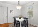 Charming dining area with a white table, four gray chairs, and a light fixture at 2236 Bailey Dr, North Charleston, SC 29405